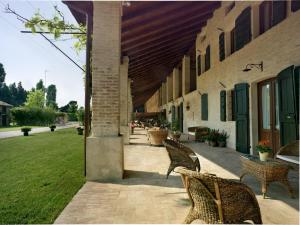 a patio with chairs and a table and a building at Tenuta Le Risare in Campo San Martino