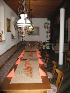 ein Esszimmer mit einem langen Tisch und einem Kronleuchter in der Unterkunft Gasthaus Zur Ölmühle in Oberderdingen