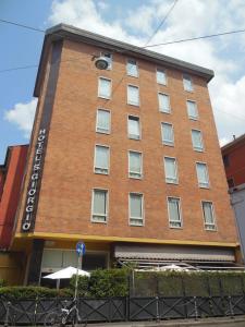 un edificio de ladrillo rojo con un cartel. en Hotel San Giorgio en Bolonia