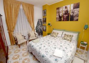 Un dormitorio con una cama y dos sillas. en I Love Art, en Cagliari