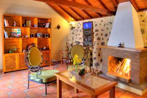 een woonkamer met een open haard en een tafel en stoelen bij HolidaynorthTenerife Casa rural Montiel in Icod de los Vinos