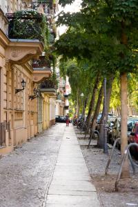 una calle con árboles y edificios y una persona caminando por la calle en BENSIMON apartments Charlottenburg, en Berlín