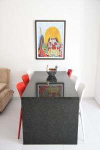 una sala da pranzo con tavolo nero e sedie rosse di Porto de Galinhas Blue Sky a Porto De Galinhas