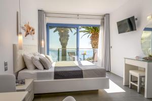 a bedroom with a bed with a view of the ocean at White Pearl in Makry Gialos