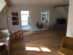 a living room with a couch and wooden floors at Gästewohnung am Museum in Braunsdorf