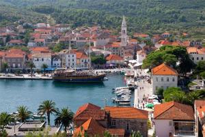 a boat in a body of water next to a town at Villa Antonio in Jelsa