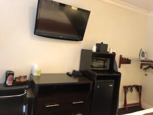 a room with a desk with a television on the wall at Seaside Inn in San Francisco