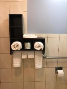 a rack with towels and toilet paper in a bathroom at Seaside Inn in San Francisco