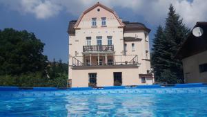 a building with a swimming pool in front of it at Villa Federer in Dolní Zálezly