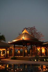 a lit up building with a pool in front of it at Mae Jo Golf Resort & Spa in San Sai
