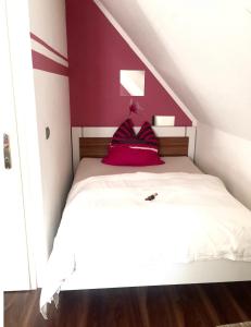 um quarto com uma cama branca e uma parede vermelha em Sweet Home em Willich