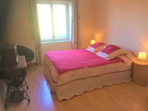 1 dormitorio con cama con sábanas rosas y ventana en la siestou, en Le Monteil