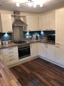 a kitchen with white cabinets and a stove top oven at Bradan in Pitlochry