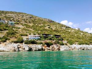 a group of houses on a hill next to the water at Villa Lori in Qeparo