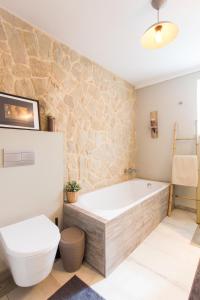 a bathroom with a bath tub and a toilet at Casa do Mundo in Calhariz