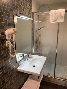 y baño con lavabo y ducha. en Hostal Falfes, en Madrid