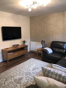 a living room with a couch and a flat screen tv at Bradan in Pitlochry