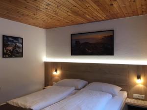 - une chambre avec deux lits et deux lumières sur le mur dans l'établissement Haus Kirschner, à Jerzens