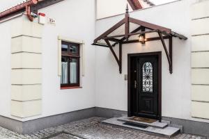 a house with a black door and a window at Sanhaus Apartments - Apartamenty Capri in Sopot