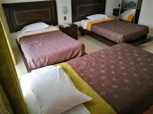 a hotel room with two beds and two pillows at Caballito de Totora in Huanchaco