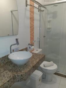 uma casa de banho com um lavatório, um WC e um chuveiro em Hotel La Brise em Cabo Frio