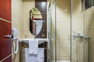 bagno con lavandino e doccia con specchio di Canadian Hotel a Laganas