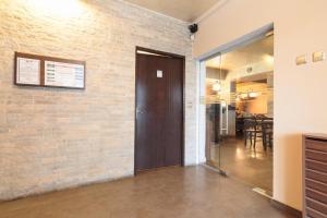 a hallway with a brick wall and a wooden door at Casa de Piatra Bistro in Cluj-Napoca