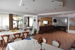 a dining room with tables and chairs and a living room at Pensiunea Steluta in Predeal