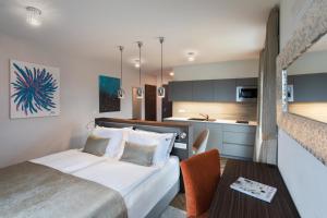 1 dormitorio con cama, mesa y cocina en Design & Wine Vila Special Bled, en Bled