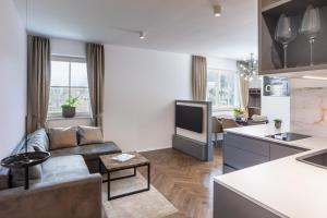 a living room with a couch and a tv and a kitchen at Design & Wine Vila Special Bled in Bled +81 photos