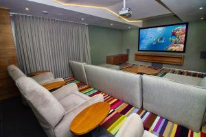 a living room with couches and a flat screen tv at Menesse the City by Casago in Playa del Carmen