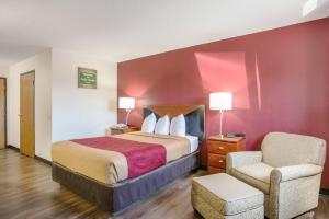 Habitación de hotel con cama y silla en Econo Lodge, en Cedar Rapids
