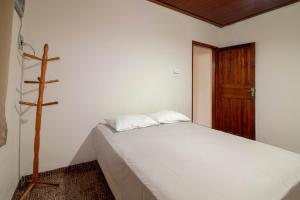 a small bedroom with a bed and a wooden door at Casa central em Bonito-MS in Bonito