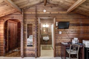 a room with a wooden wall with a desk and a television at Rib Waters Inn in Rib Lake