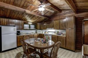 a kitchen with a table and a white refrigerator at Rib Waters Inn in Rib Lake