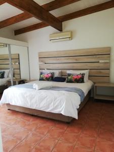a bedroom with a large bed with a wooden headboard at San Lameer Villa 3103 in Southbroom