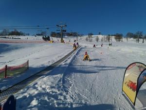 un grupo de personas esquiando por una pista cubierta de nieve en Apartmán Astomo, en Vrchlabí