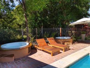 a patio with two lounge chairs and a hot tub at Ruca Lemu in Chascomús