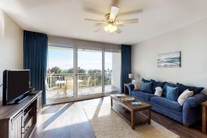 a living room with a blue couch and a large window at Sterling Shores in Destin