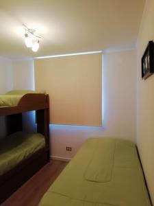 Un dormitorio con dos literas y una ventana. en Costa Papudo, en Papudo