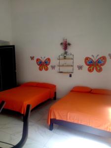 two beds in a room with butterflies on the wall at Casa Santuario Hotel Boutique in Guadalajara