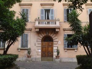 un edificio con balcón y puerta de madera en Napoleone Suite en Roma