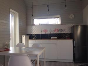 a kitchen with a table and a refrigerator at Holiday house Ausekļa namiņš in Cēsis