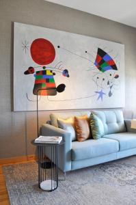 a living room with a blue couch and a painting at Apartment by the Sea in Porto