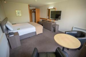um quarto de hotel com uma cama, uma mesa e cadeiras em Kingsgate Hotel Te Anau em Te Anau