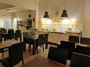 a restaurant with tables and chairs and a kitchen at Sundsvall City Hotel in Sundsvall
