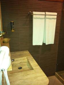 a bathroom with a wooden counter with a toilet and towels at Hotel Sarajet e Pashait 1 in Dhërmi