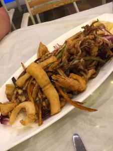 une assiette de nourriture avec des frites sur une table dans l'établissement Hotel Sarajet e Pashait 1, à Dhërmi