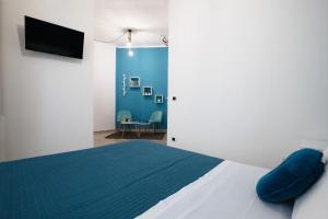 a bedroom with a bed and a tv on a wall at B&B Vico 10 in Guspini