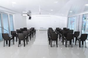 a conference room with black chairs and windows at Hotel Cayapo in Puerto López